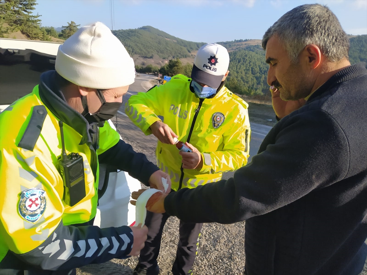 Polis devrilen tırdan çıkardığı sürücünün yaralanan elini sardı