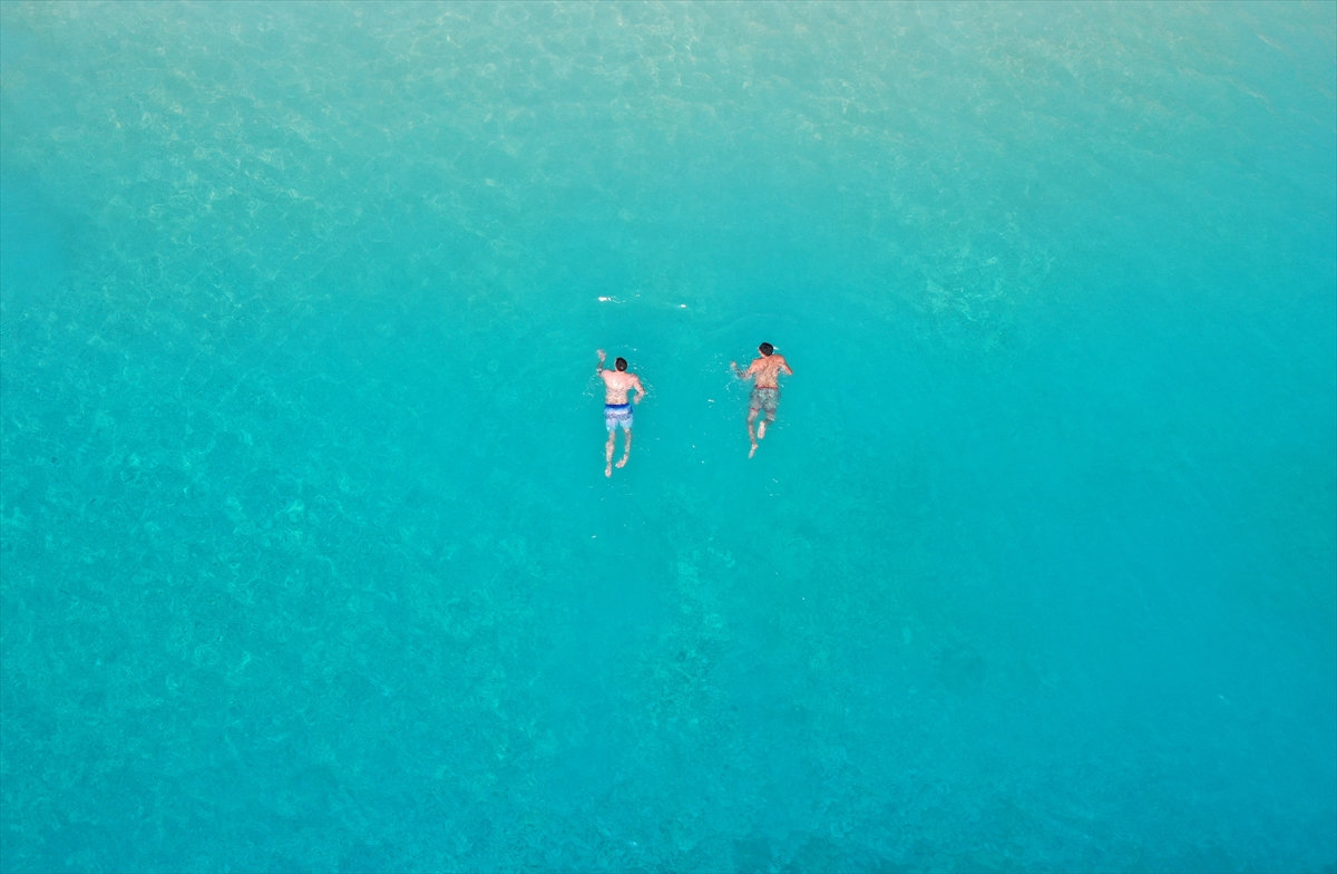 Antalya'nın ünlü Kaputaş Plajı'na gelen turistler güzel havada denize girdi